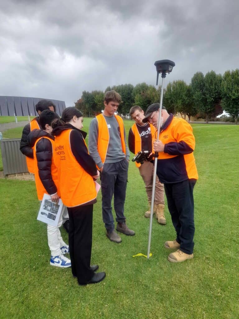 work experience group on site with surveying equipment